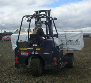 Palfinger CR65 Crayler forklift moving materials over rough terrain to job site.